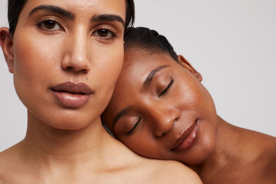 one woman with her head on the shoulder of another.